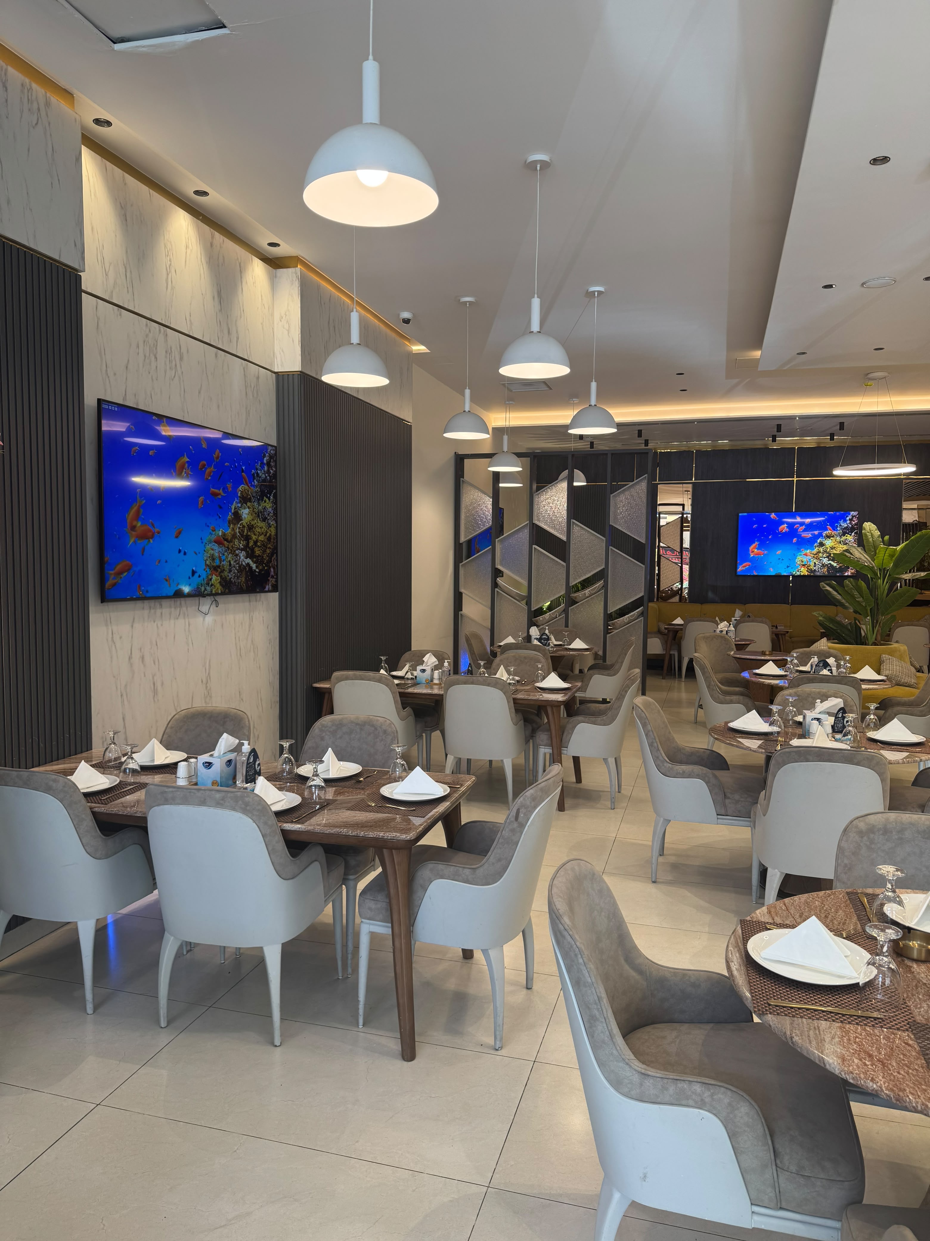 Pendant-lit tables along the marble feature wall